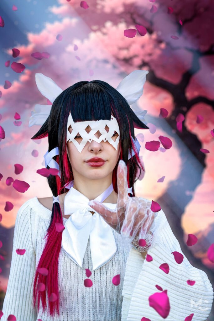 Foto di una cosplayer che porta il personaggio di Columbina di Genshin Impact. Sullo Sfondo un ciliegio in fiore.