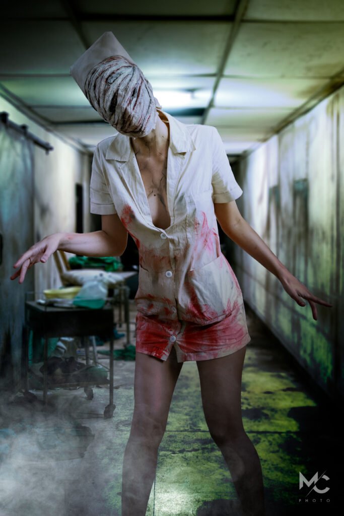 Foto di un cosplayer che porta il personaggio della Nurse di Silent Hill. Sullo sfondo un corridoio in cattivo stato di manutenzione.